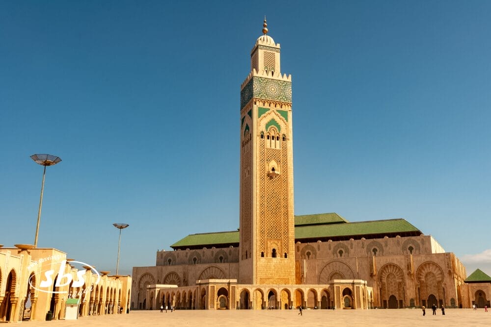 La Moschea di Hassan II a Casablanca, in Marocco, presenta un minareto alto e decorato, ingressi ad arco e intricati disegni geometrici. Scoprite questo punto di riferimento con un tour di Casablanca e ammirate il meglio del Marocco con poche persone che passeggiano nelle vicinanze.