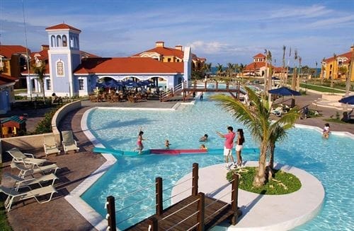 L'Iberostar Playa Alameda è un Searesort caratterizzato da edifici color pastello con tetti rossi attorno a una grande piscina all'aperto. Le famiglie nuotano e si rilassano, mentre altri si riuniscono vicino a una palma presso il ponte di legno nelle giornate di sole.