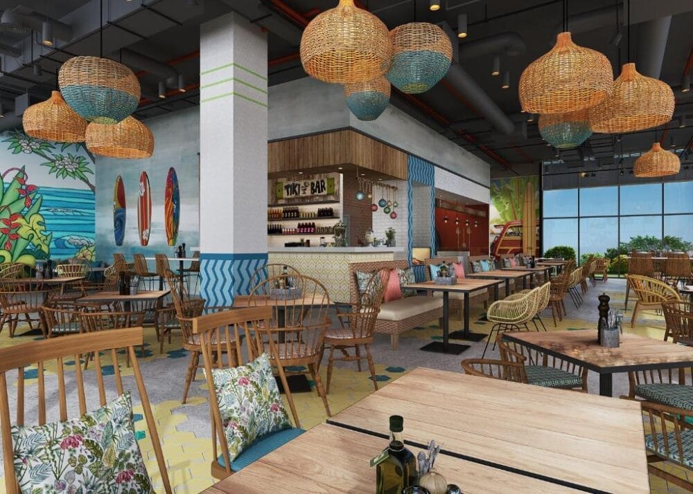 Il ristorante a tema tropicale del Centara Mirage è caratterizzato da tavoli in legno, sedie in vimini, cuscini colorati, decorazioni con tavole da surf, un tiki bar centrale, vivaci opere d'arte alle pareti e grandi finestre, che evocano il fascino di una fuga in un resort sulla spiaggia.