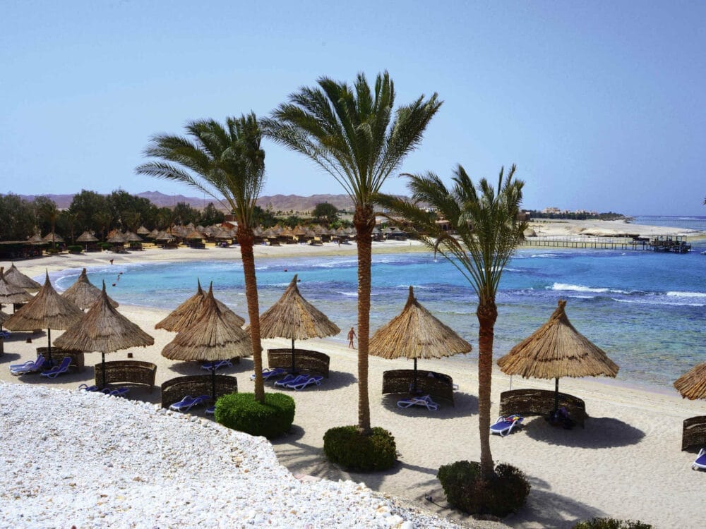 La spiaggia soleggiata del Movenpick Resort El Quseir è caratterizzata da acque cristalline, ombrelloni di paglia, palme e sedie a sdraio lungo l'arenile. Il litorale dolcemente curvo e la vegetazione lussureggiante arricchiscono questo sereno Resort in Egitto.