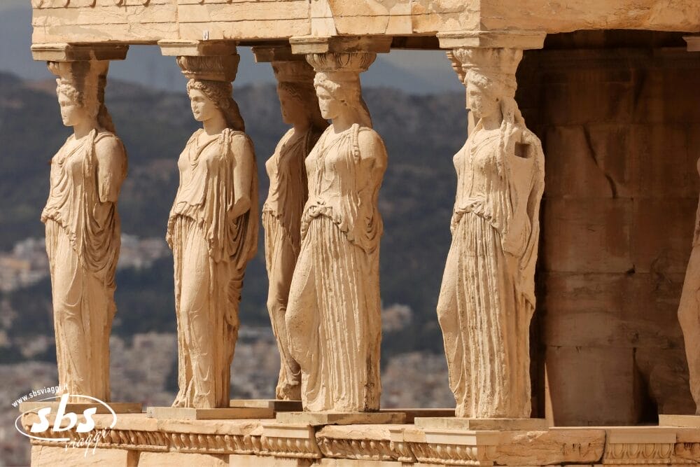 Una vista ravvicinata delle Cariatidi dell'Eretteo, antiche statue femminili greche che fungono da colonne e che sostengono il portico del tempio sull'Acropoli di Atene, con Bozza automatica sullo sfondo.