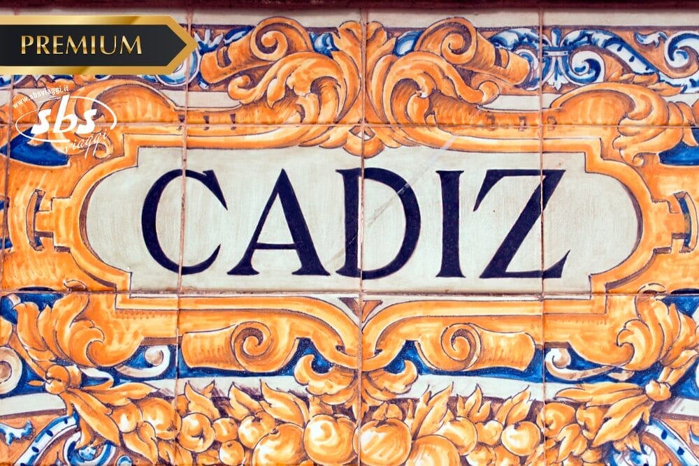 Piastrelle ornamentali in ceramica con motivi floreali e la scritta "CADIZ" in grassetto nero al centro. Nell'angolo superiore sinistro sono presenti le etichette: "PREMIUM", "SBS" e "Bozza automatica" in oro e bianco.