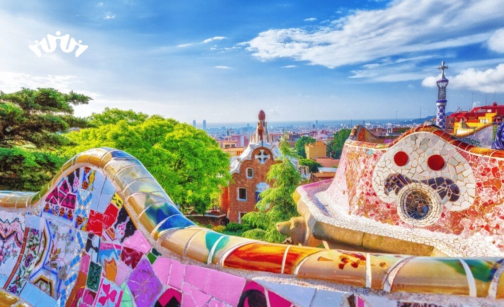 Panchine colorate a mosaico si snodano nel Park Güell di Barcellona, in Spagna, dove il verde lussureggiante e gli edifici unici fanno da cornice al paesaggio urbano: una tappa indimenticabile di MSC World Asia crociera Mediterraneo in partenza da Civitavecchia.